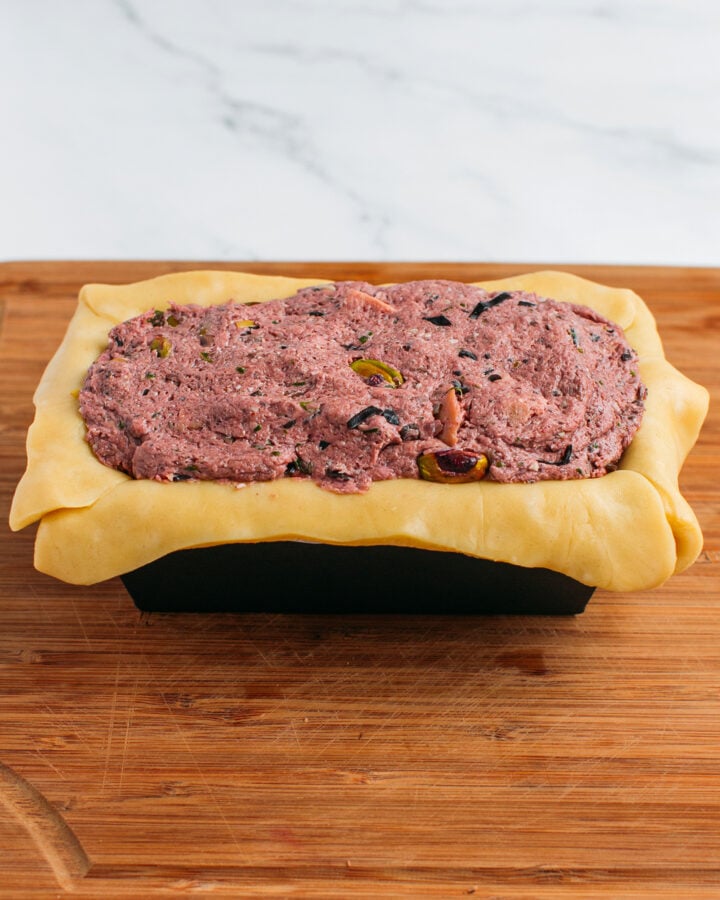 Baking pan filled with pie crust and mushroom filling.