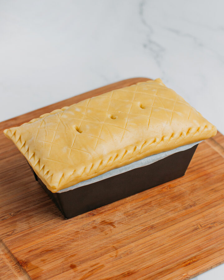 Vegan pâté en croute in a rectangular pan before baking.