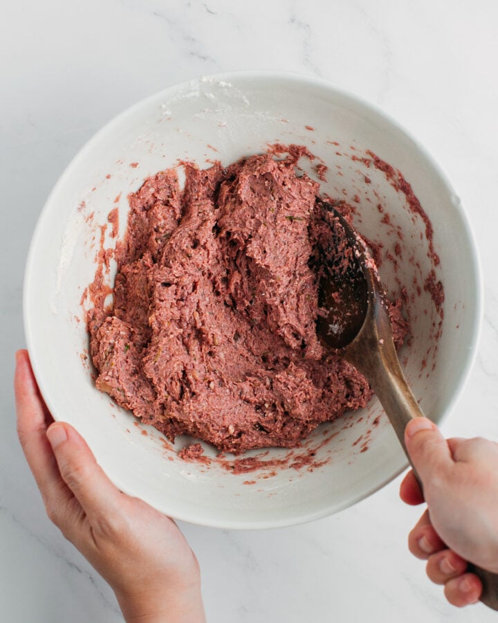 Mixing mushroom paste with flour and vital wheat gluten in a bowl.