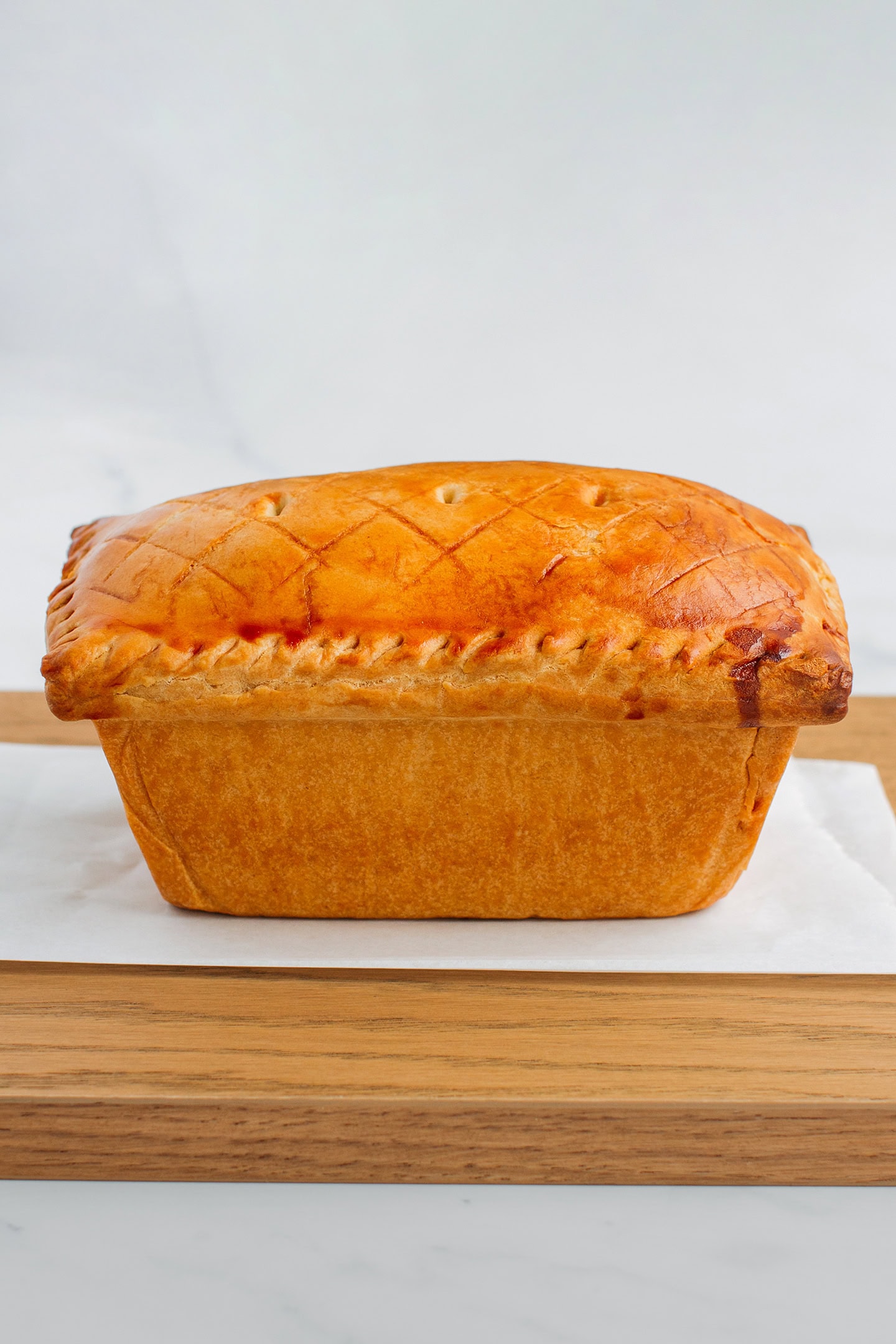 Vegan baked terrine pie on a wooden board.