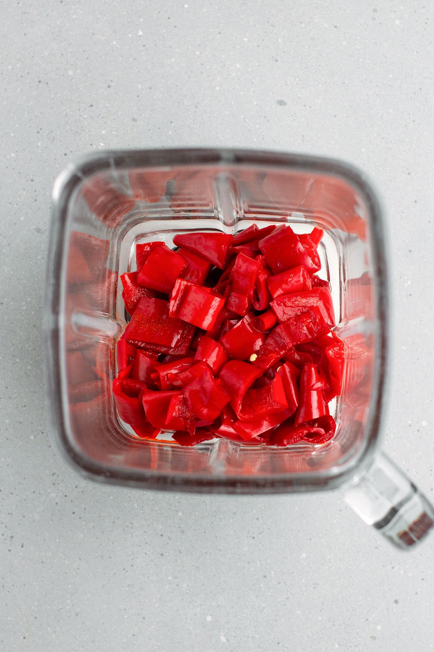 Chopped fermented cayenne peppers in a blender.