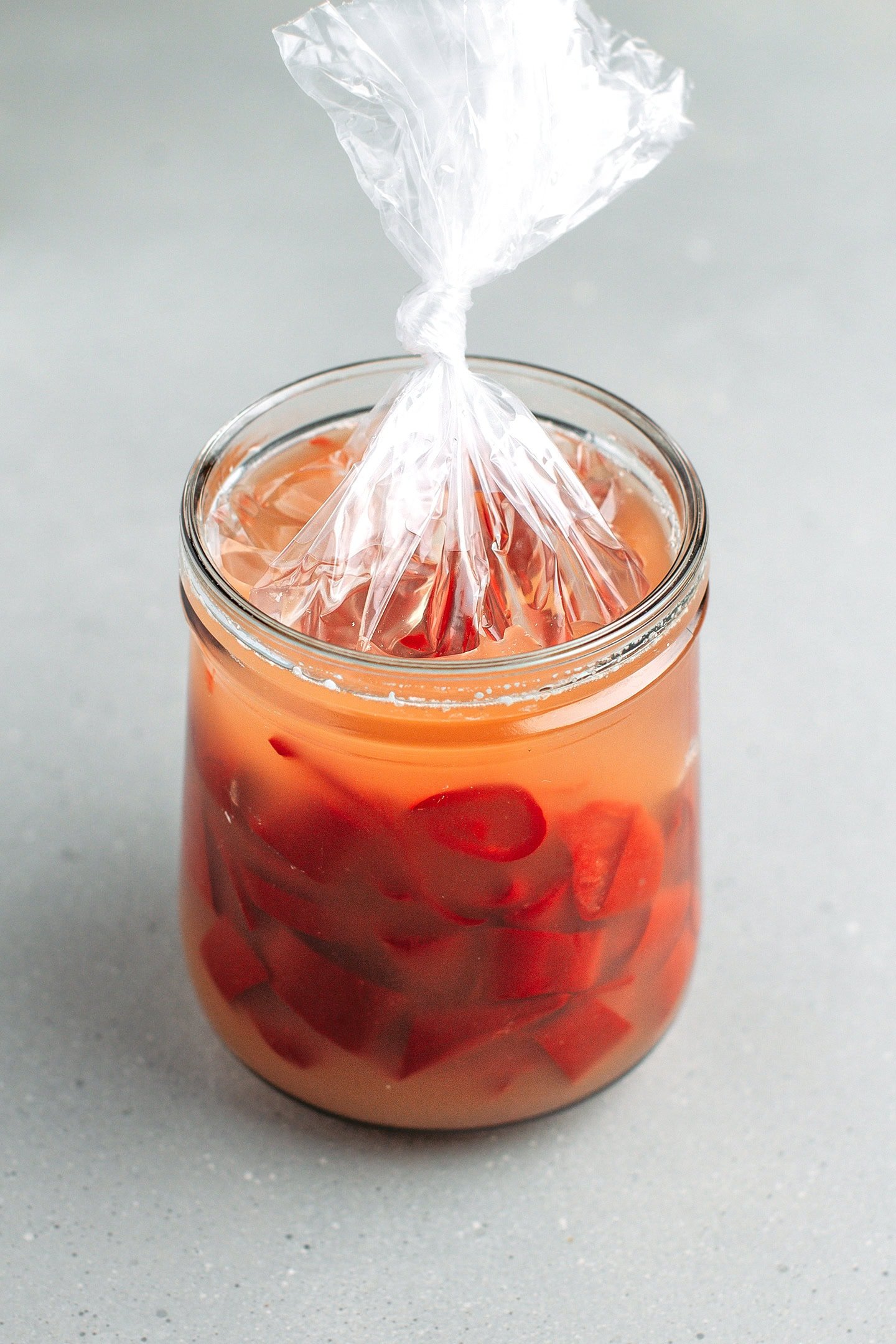 Glass jar filled with chopped fermented red cayenne peppers.