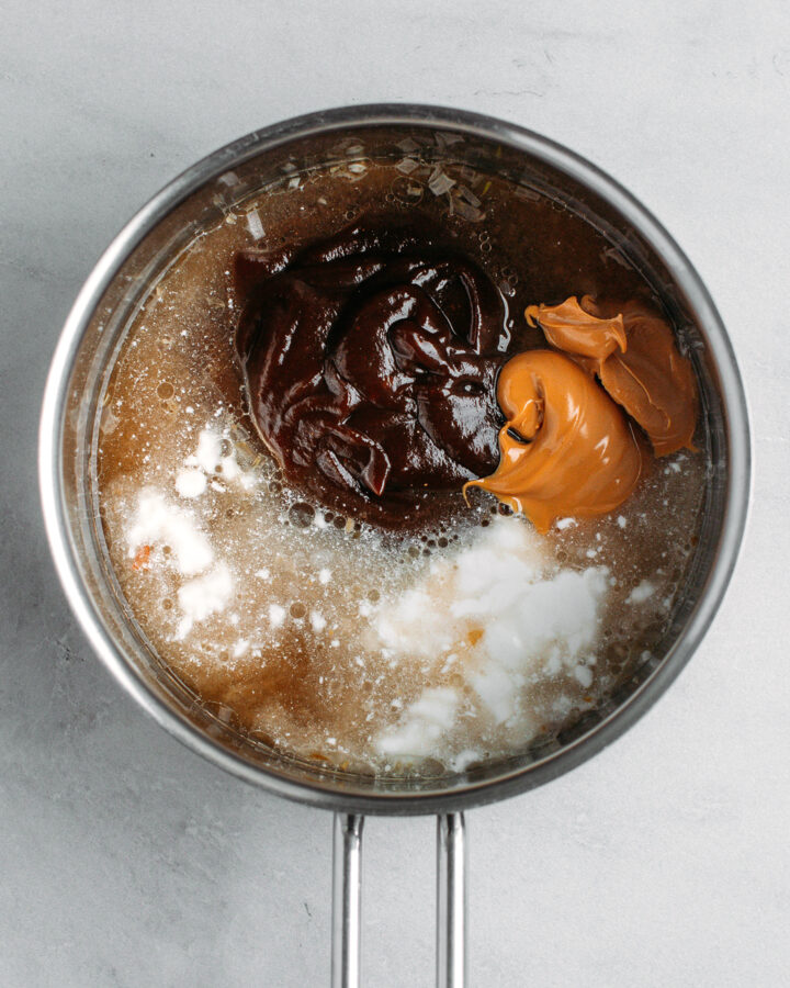 Hoisin sauce, peanut butter, coconut milk, and water in a saucepan.