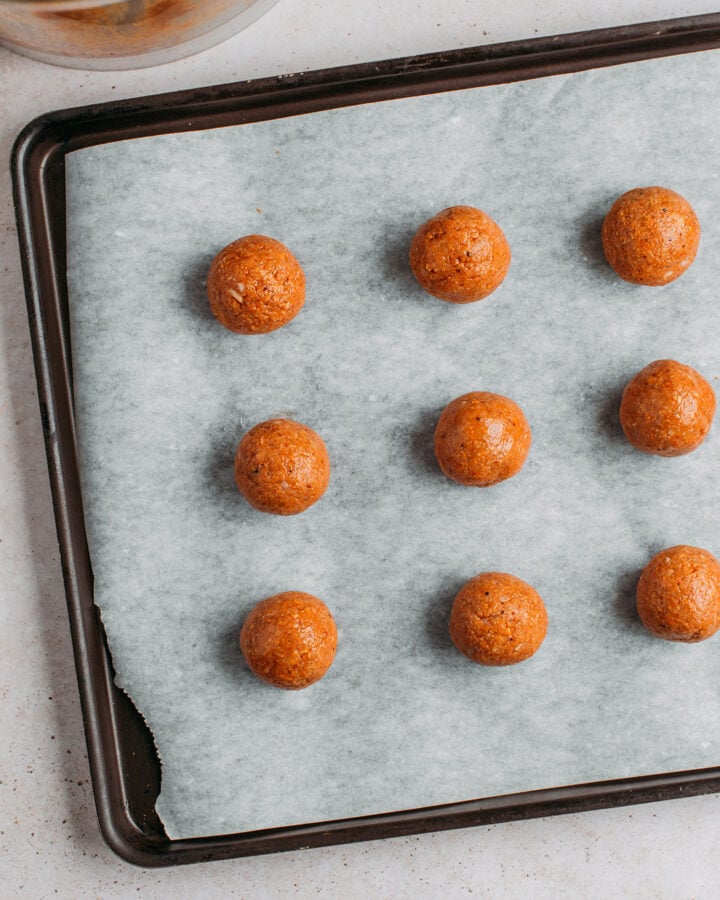 Unbaked fonio balls on a baking sheet.