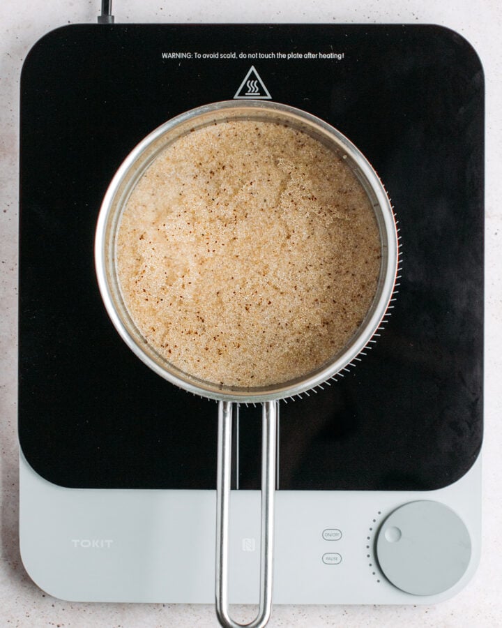 Fonio cooking in boiling water in a saucepan.