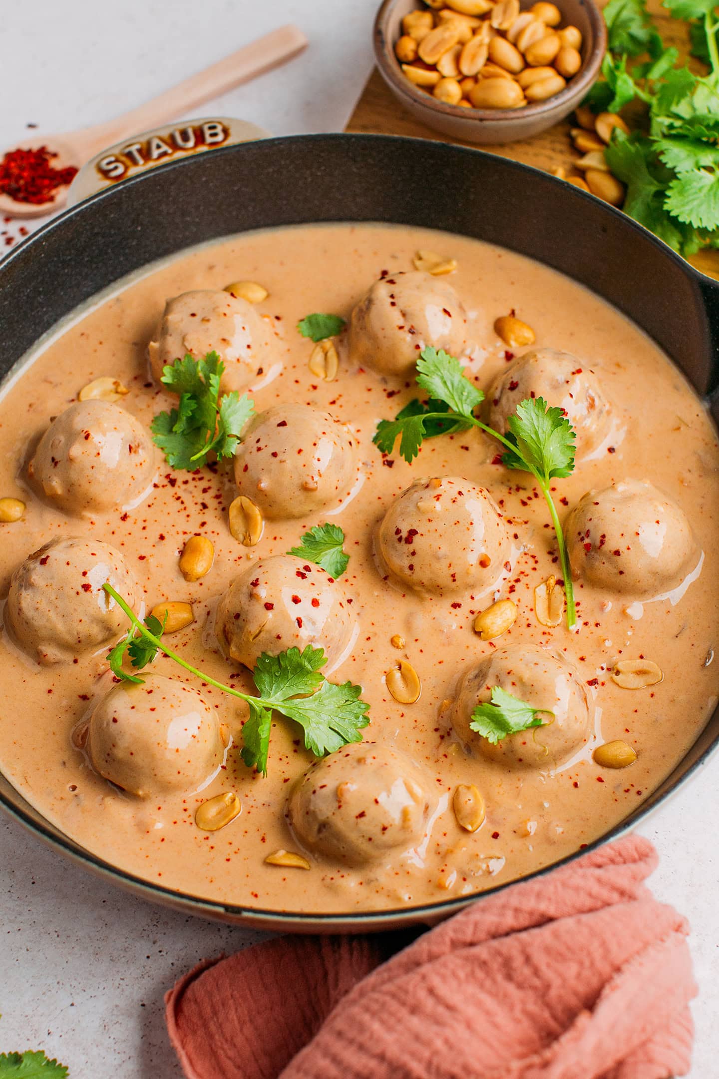 Fonio balls in a creamy peanut butter sauce in a skillet.