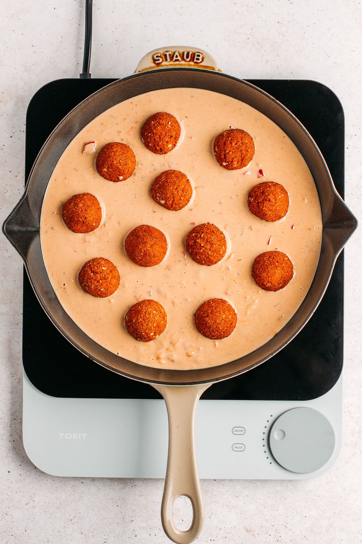 Fonio balls in peanut sauce in a skillet.