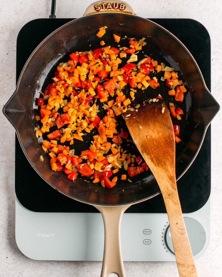 Sautéed carrots and bell peppers in a skillet.