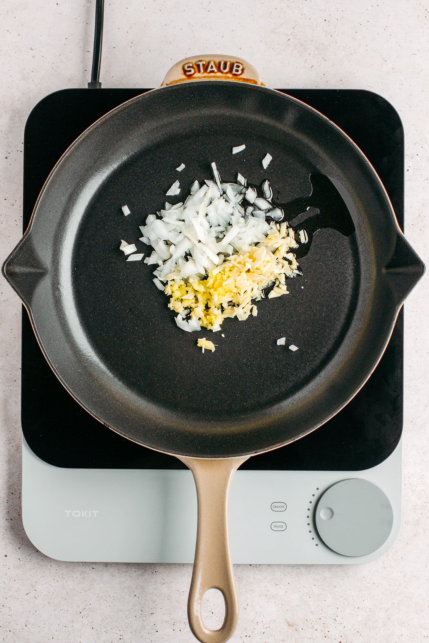 Minced garlic, ginger, and onion in a skillet.