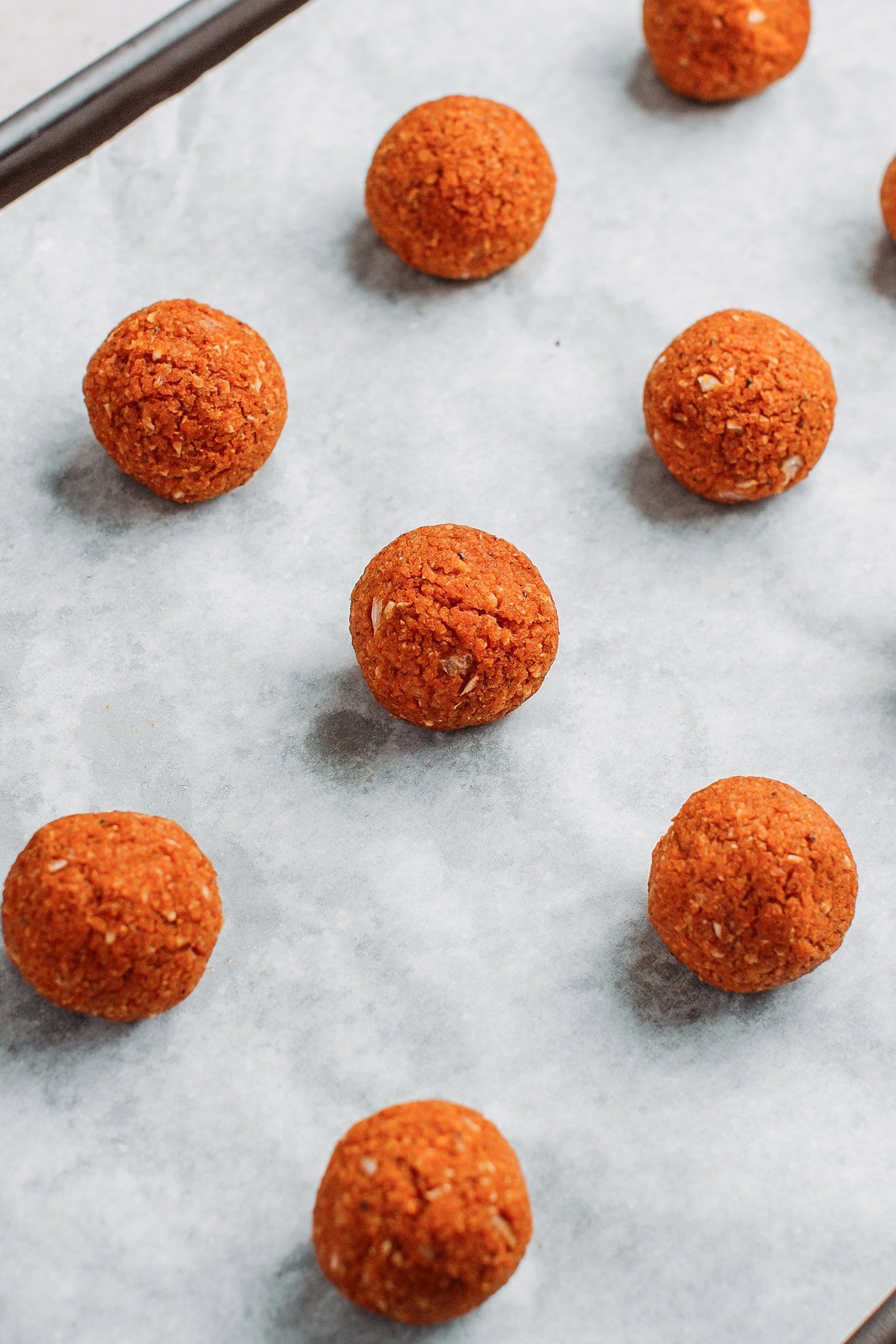 Baked fonio balls on a baking sheet.