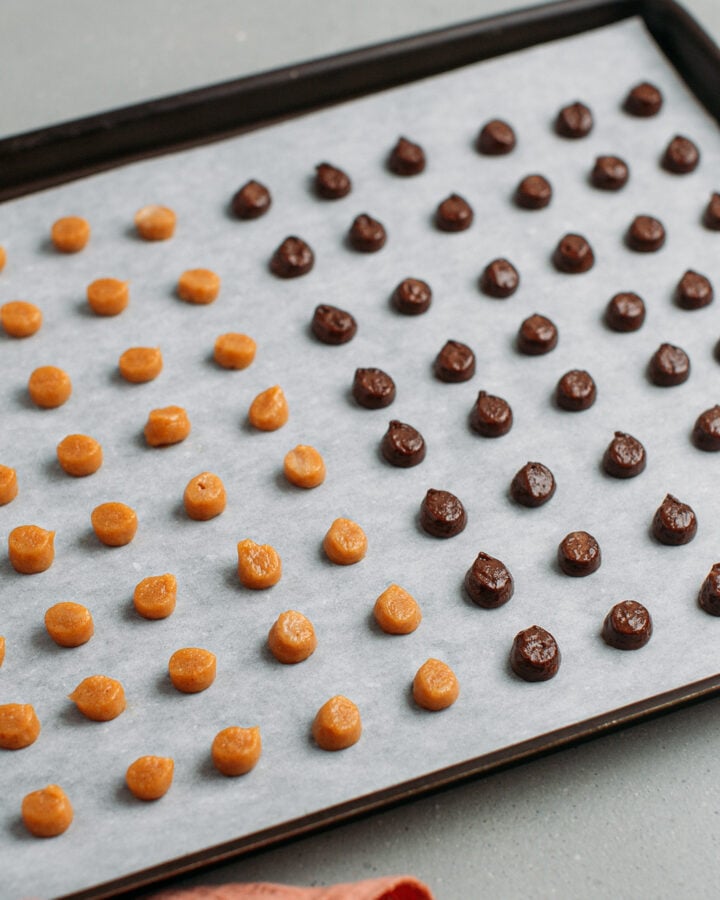 Piped chocolate and peanut butter cereal on a baking sheet.