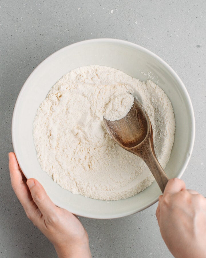 Stirring flour with baking powder and baking soda.