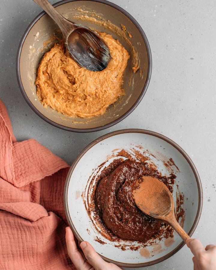 Two bowls containing peanut butter batter and chocolate batter.