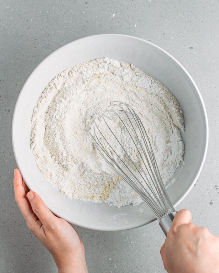 Whisking buckwheat flour with rice flour and tapioca starch in a bowl.
