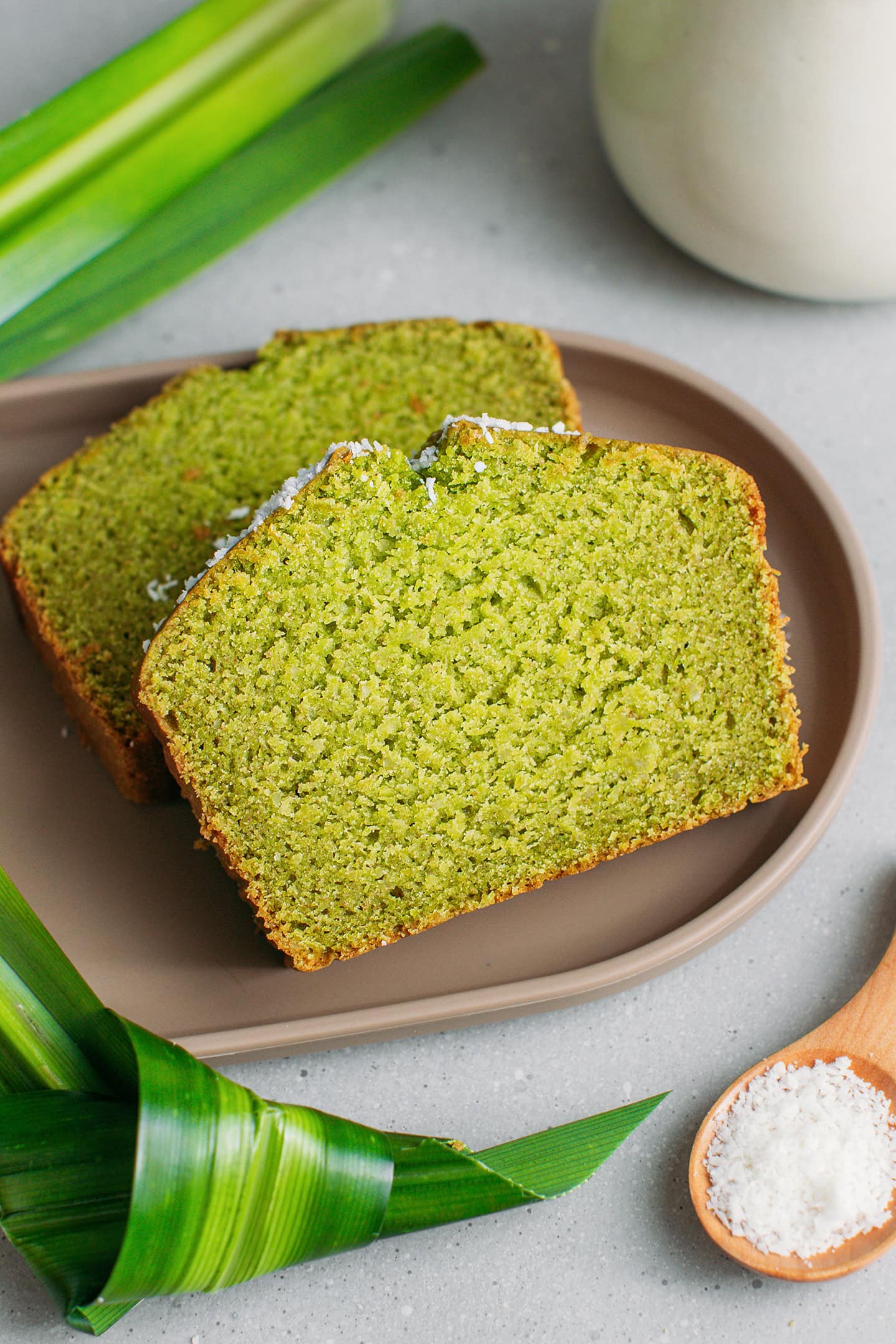 Two slices of pandan bread on a brown platter.