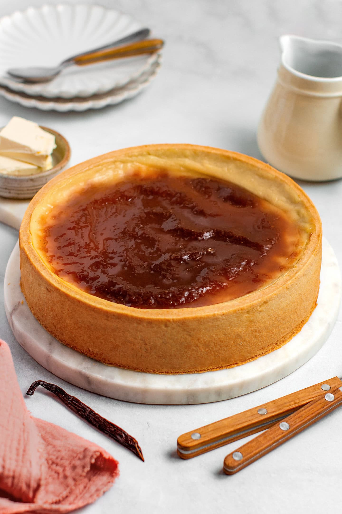 Whole vegan custard tart on a round marble platter.