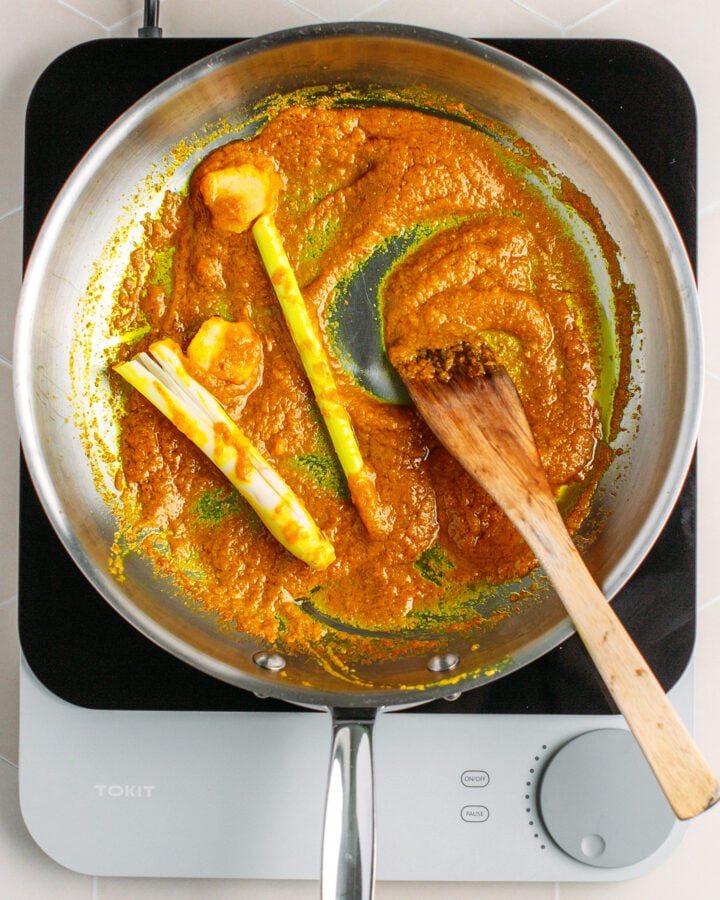 Sautéed chili paste and lemongrass in a skillet.
