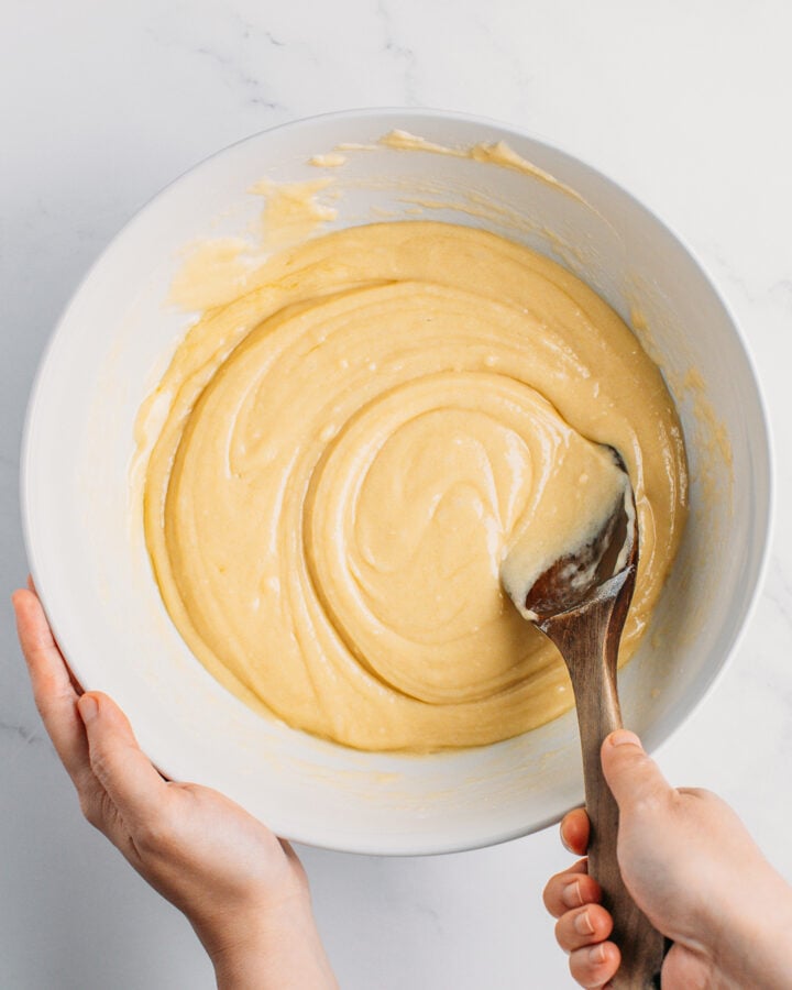 Stirring vanilla cake batter in a mixing bowl.