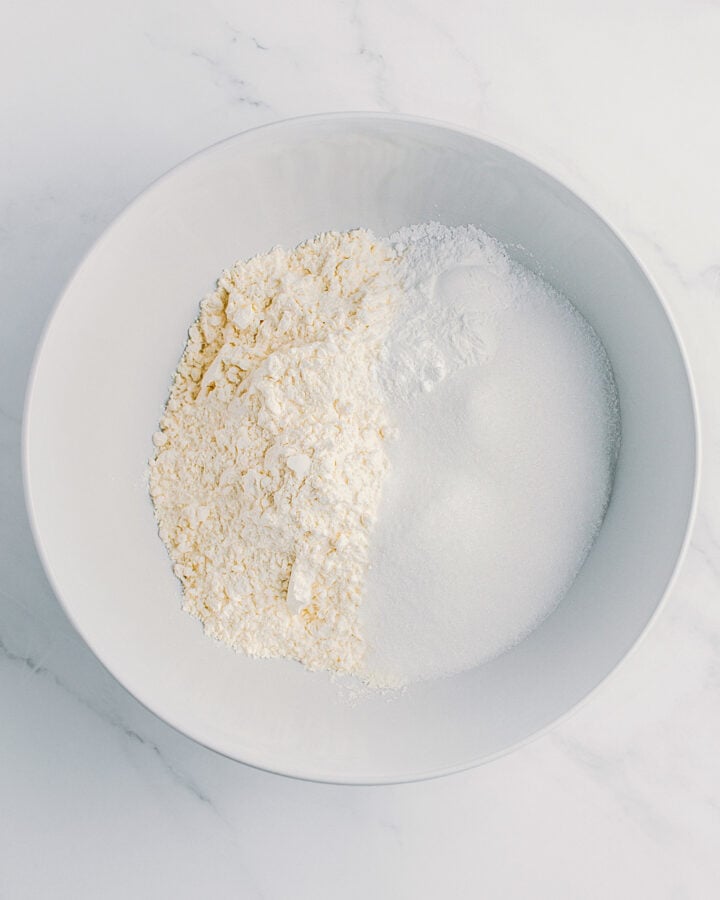 Flour, sugar, and baking powder in a bowl.
