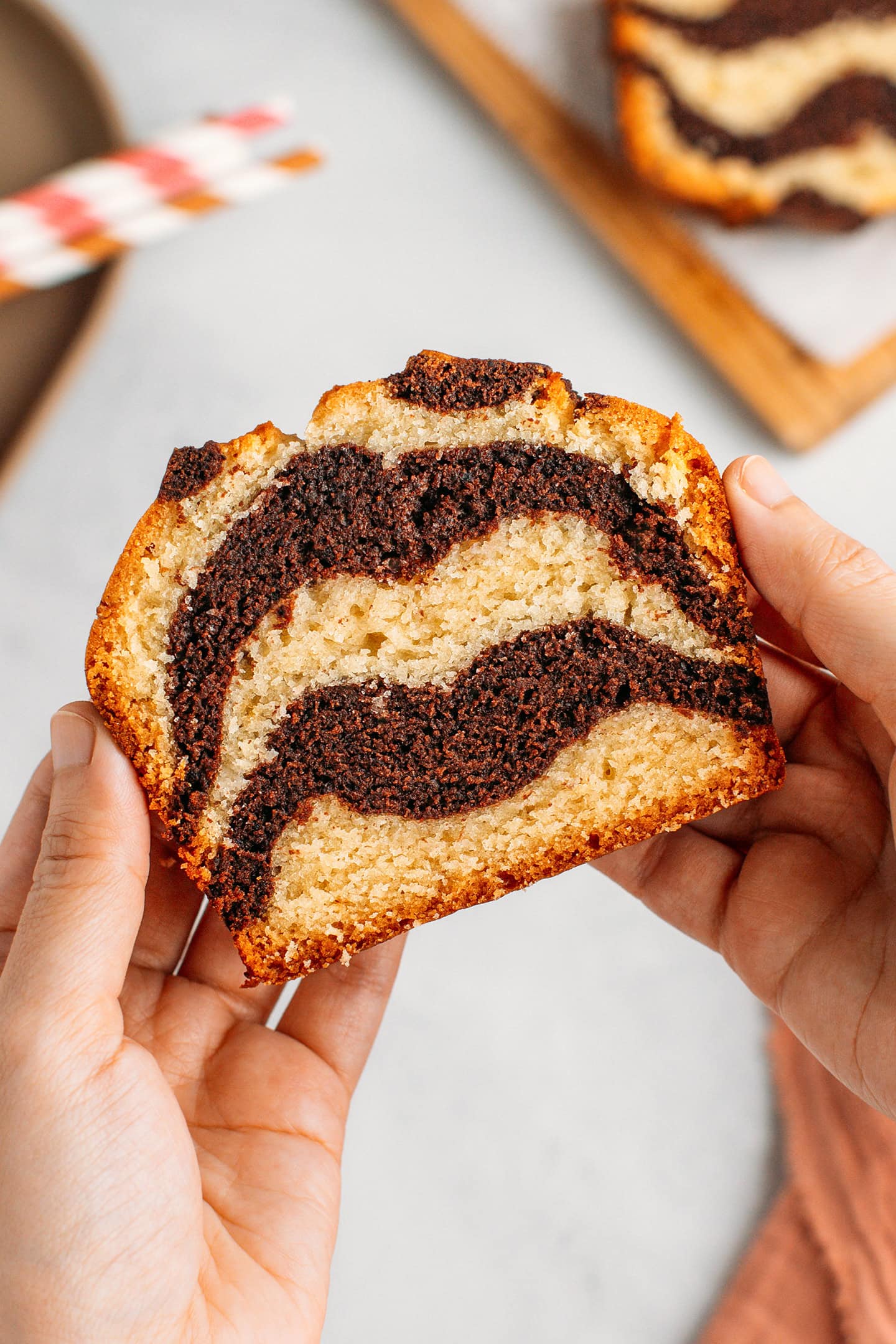 Holding a slice of vanilla and chocolate marble cake.
