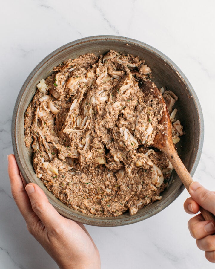 Mixing mushroom paste with shredded jackfruit in a bowl.