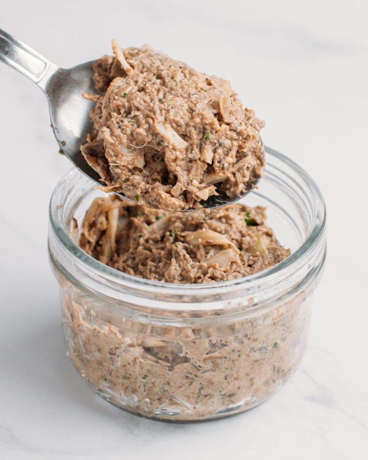 Filling a glass jar with vegan rillettes.