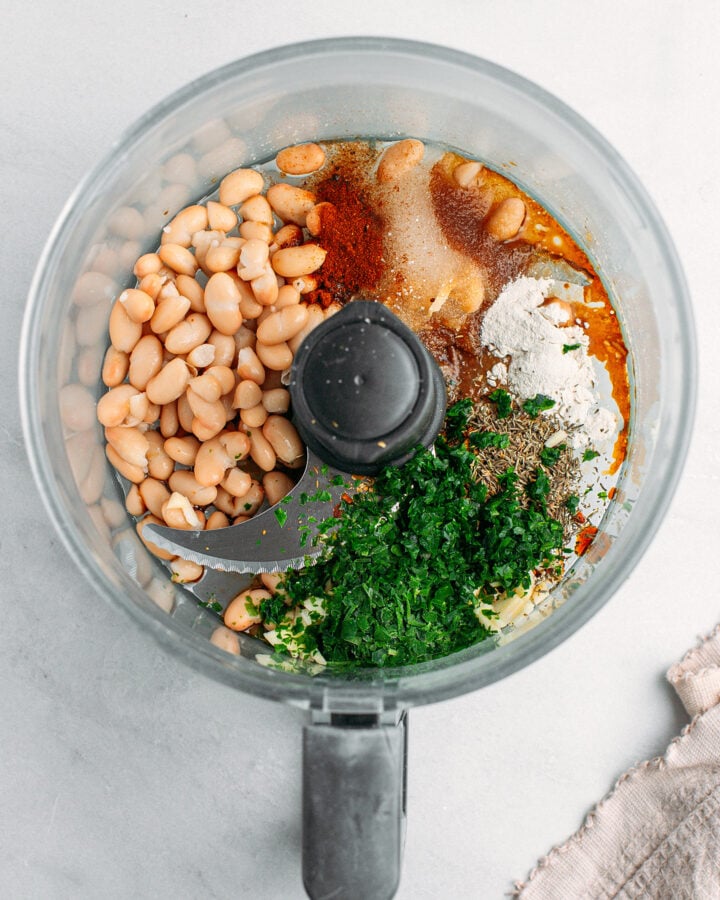 Cooked white beans, parsley, herbs, soy sauce, and sugar, in a food processor.