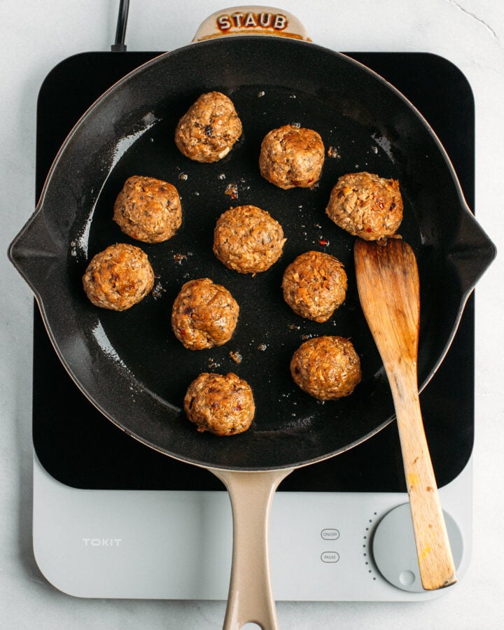 Sautéed vegan meatballs in a skillet.