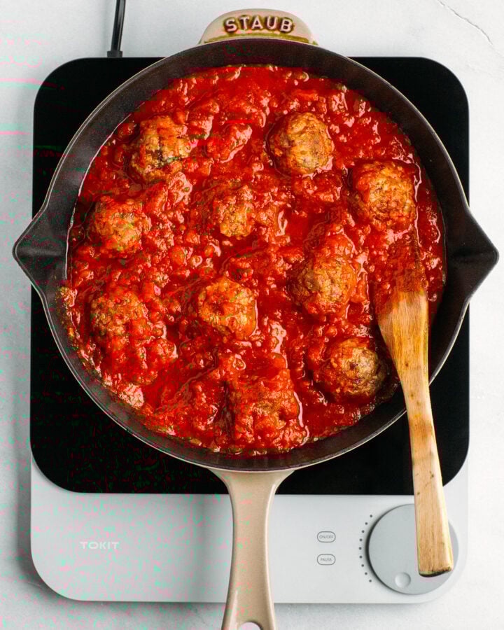 Vegan meatballs with tomato sauce in a skillet.