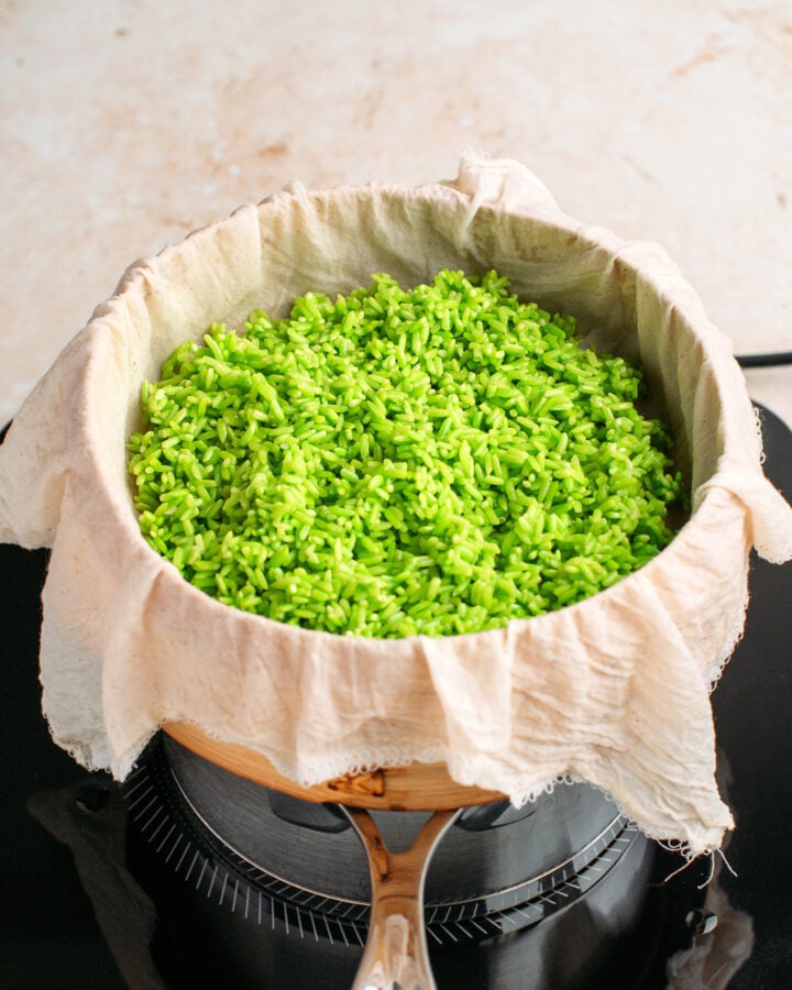 Uncooked pandan rice in a bamboo basket steamer.