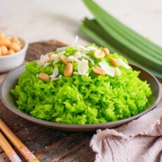 Pandan sticky rice topped with peanuts and coconut flakes.
