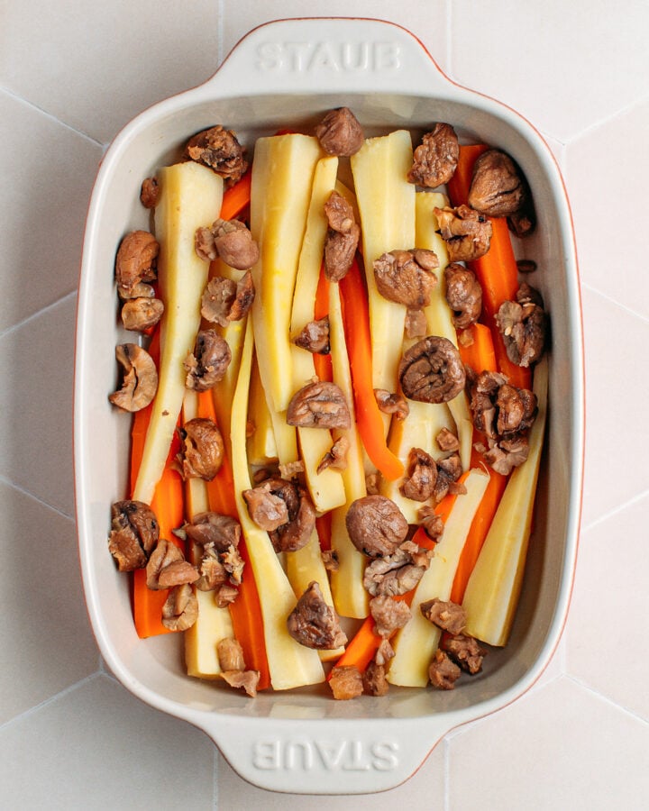 Parsnips, carrots, and chestnuts in a baking dish.