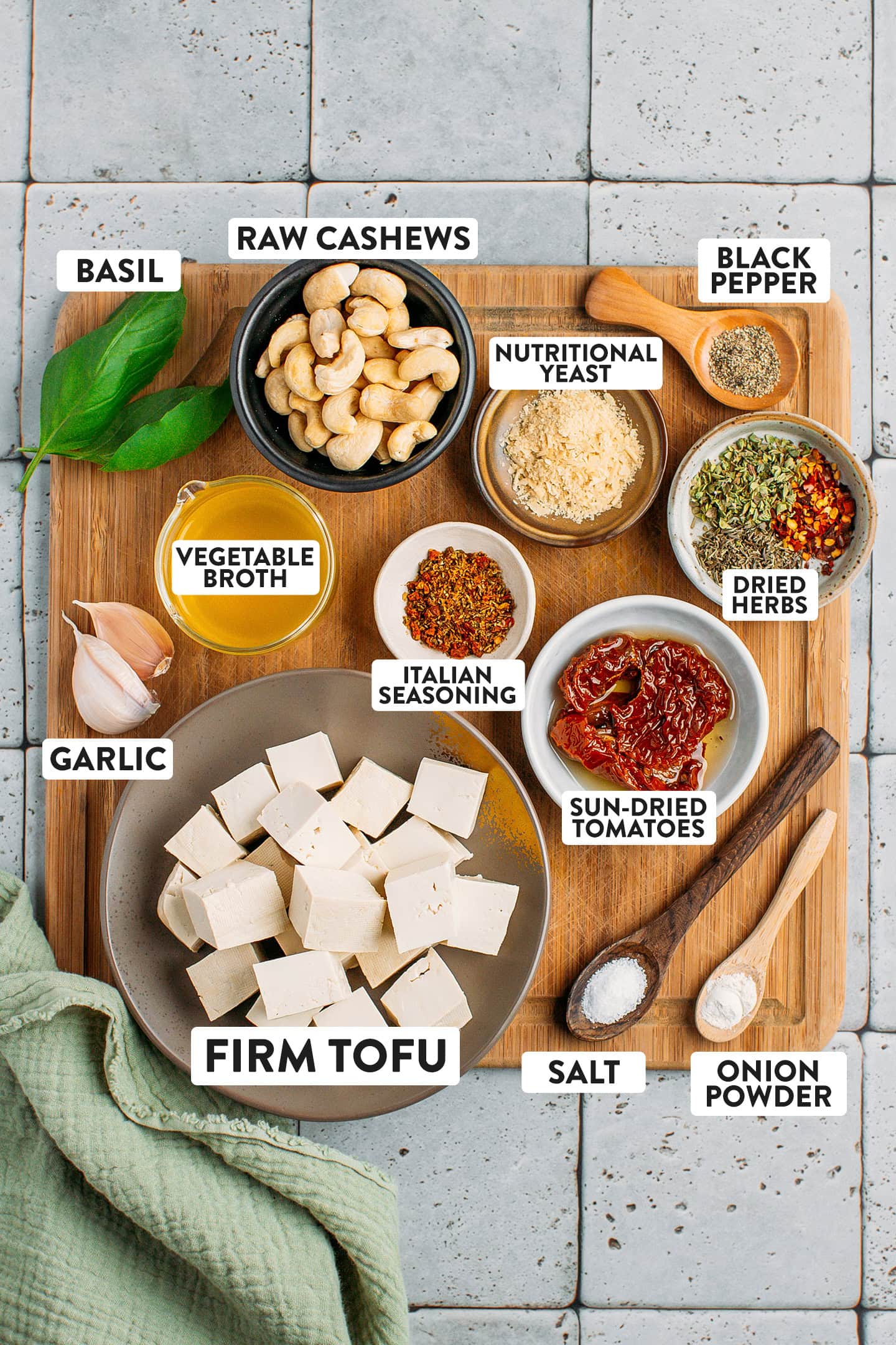 Ingredients like tofu, sun-dried tomatoes, vegetable broth, cashews, and garlic.