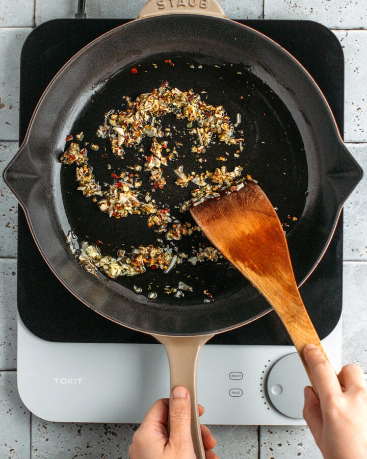 Sautéed garlic and dried herbs in a skillet.