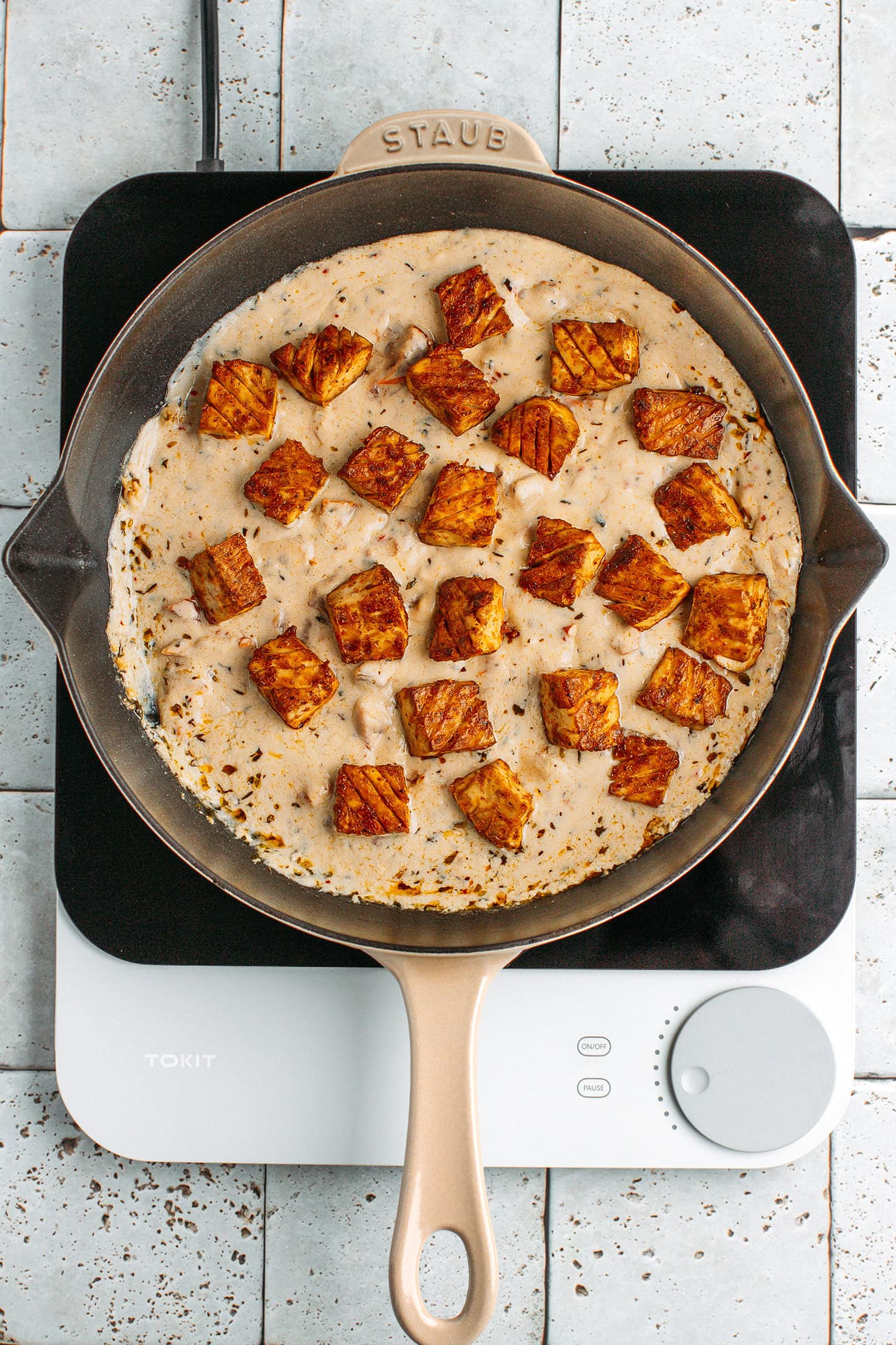 Baked tofu and Marry Me sauce in a skillet.