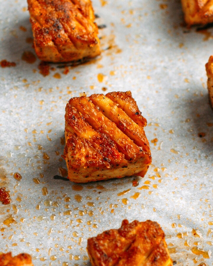 Close-up of a piece of baked tofu on a baking sheet.