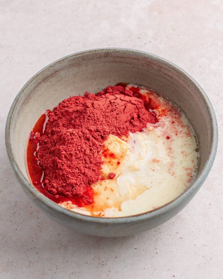 Cake batter, strawberry powder, and lemon juice in a mixing bowl.