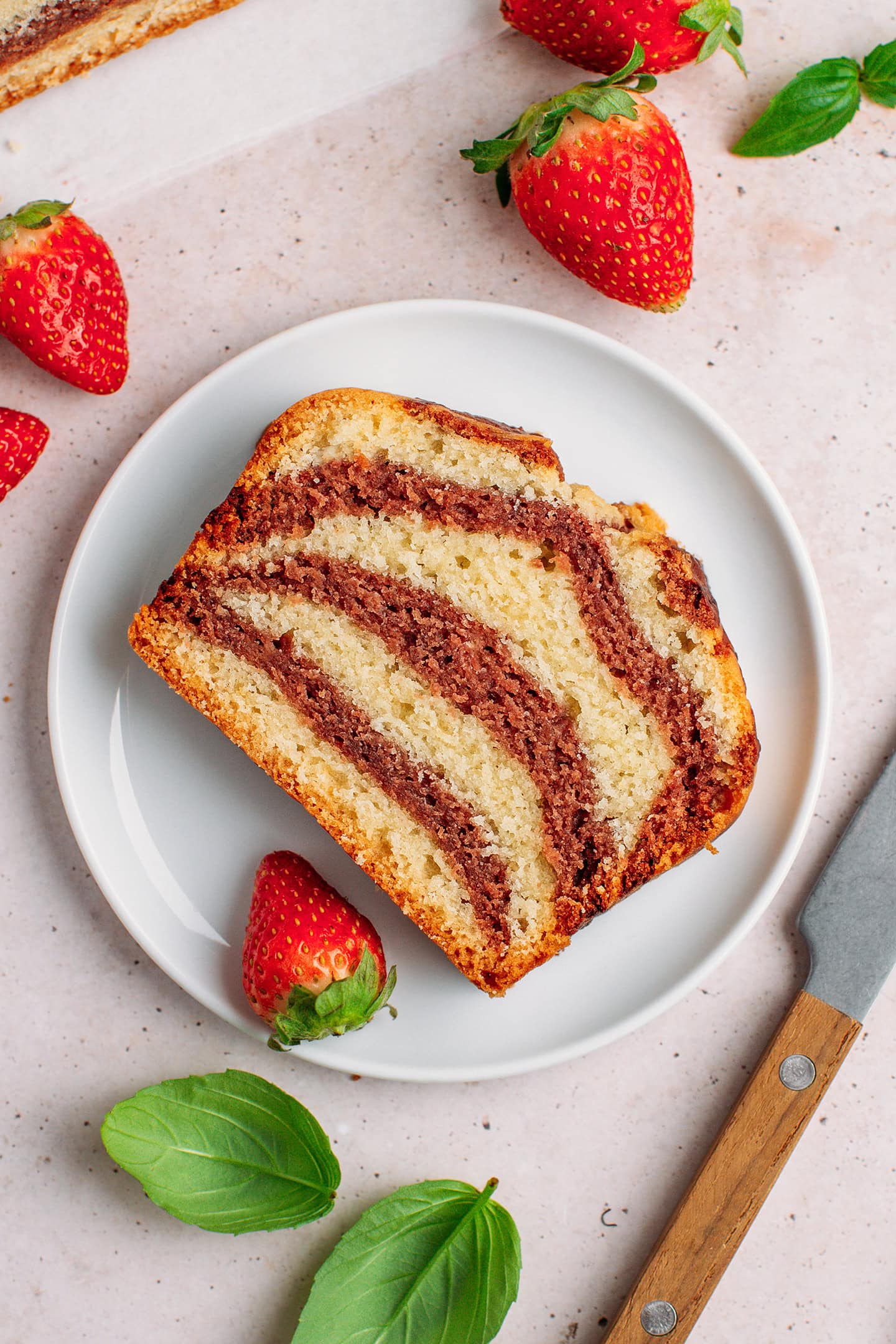 Slice of strawberry marble cake on a small white plate.