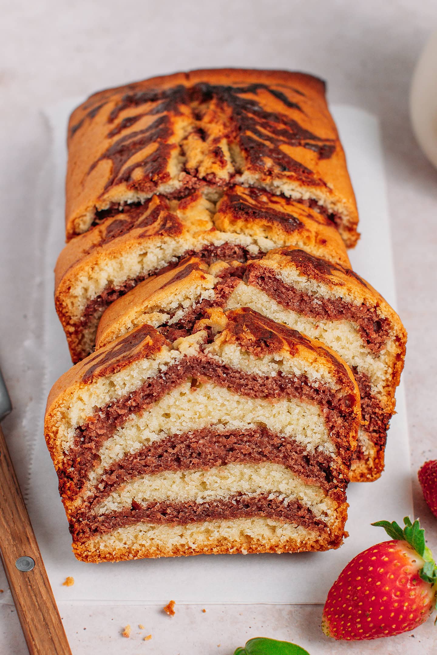 Sliced strawberry marble cake on a white countertop.