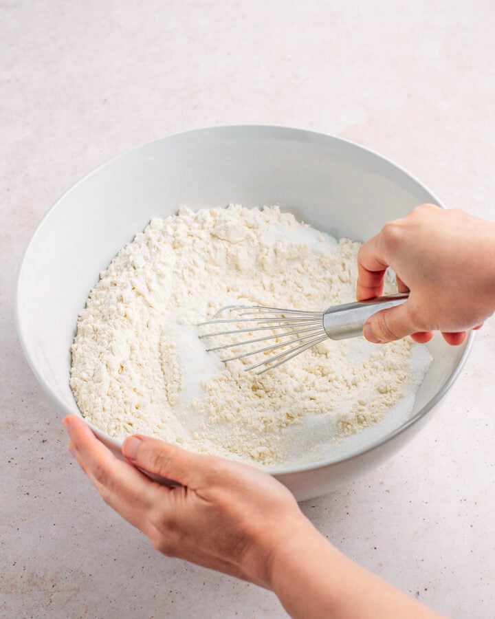 Whisking flour, sugar, baking powder, and salt, in a mixing bowl.