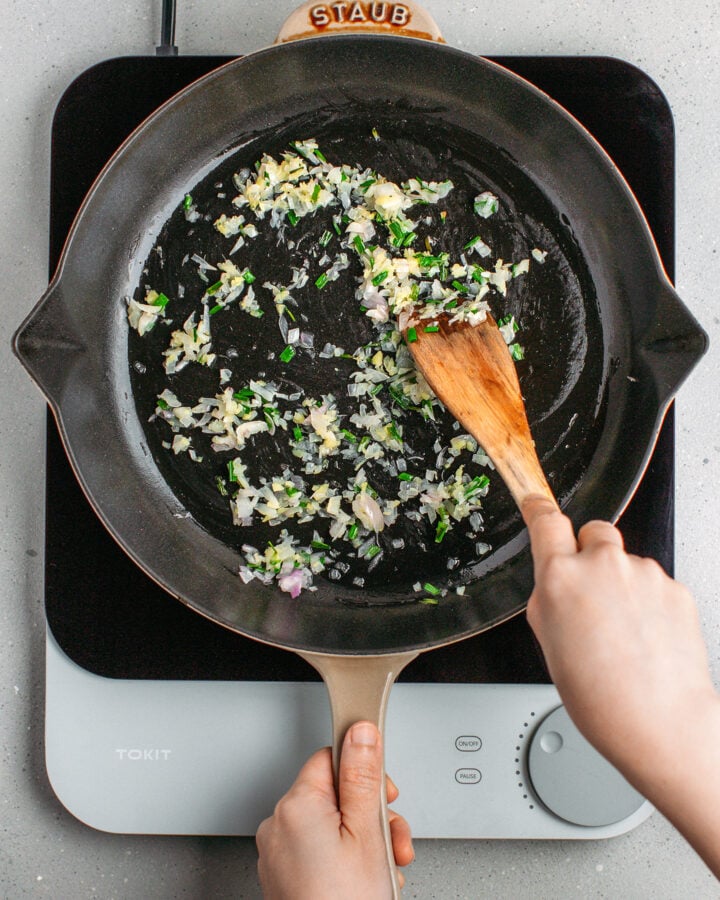 Sautéed garlic, shallots, and ginger in a skillet.