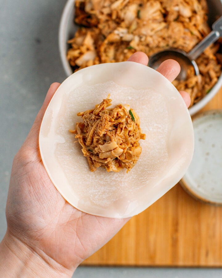 Tablespoon of jackfruit filling on a round dumpling wrapper.