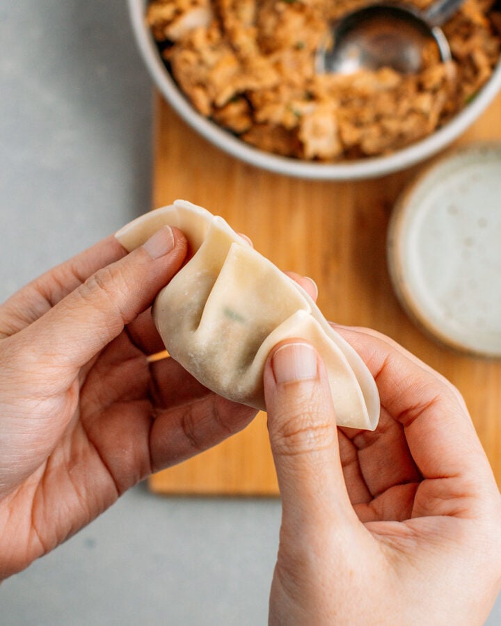 Wrapping jackfruit filling in a dumpling wrapper.