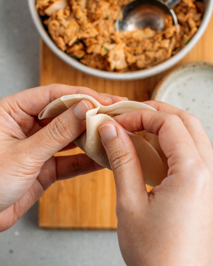 Wrapping jackfruit filling in a dumpling wrapper.