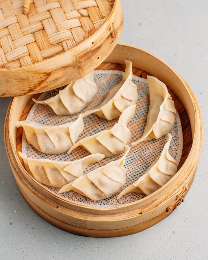 Uncooked jackfruit dumplings inside a bamboo basket steamer.