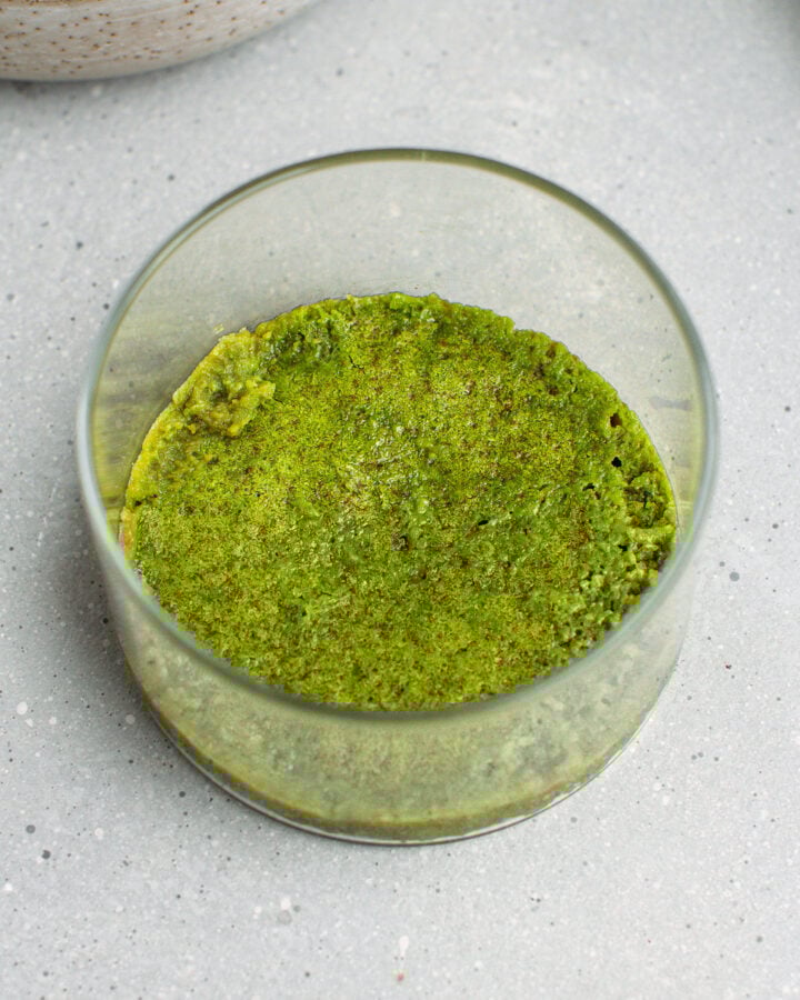 Matcha sponge cake in the bottom of a ramekin.