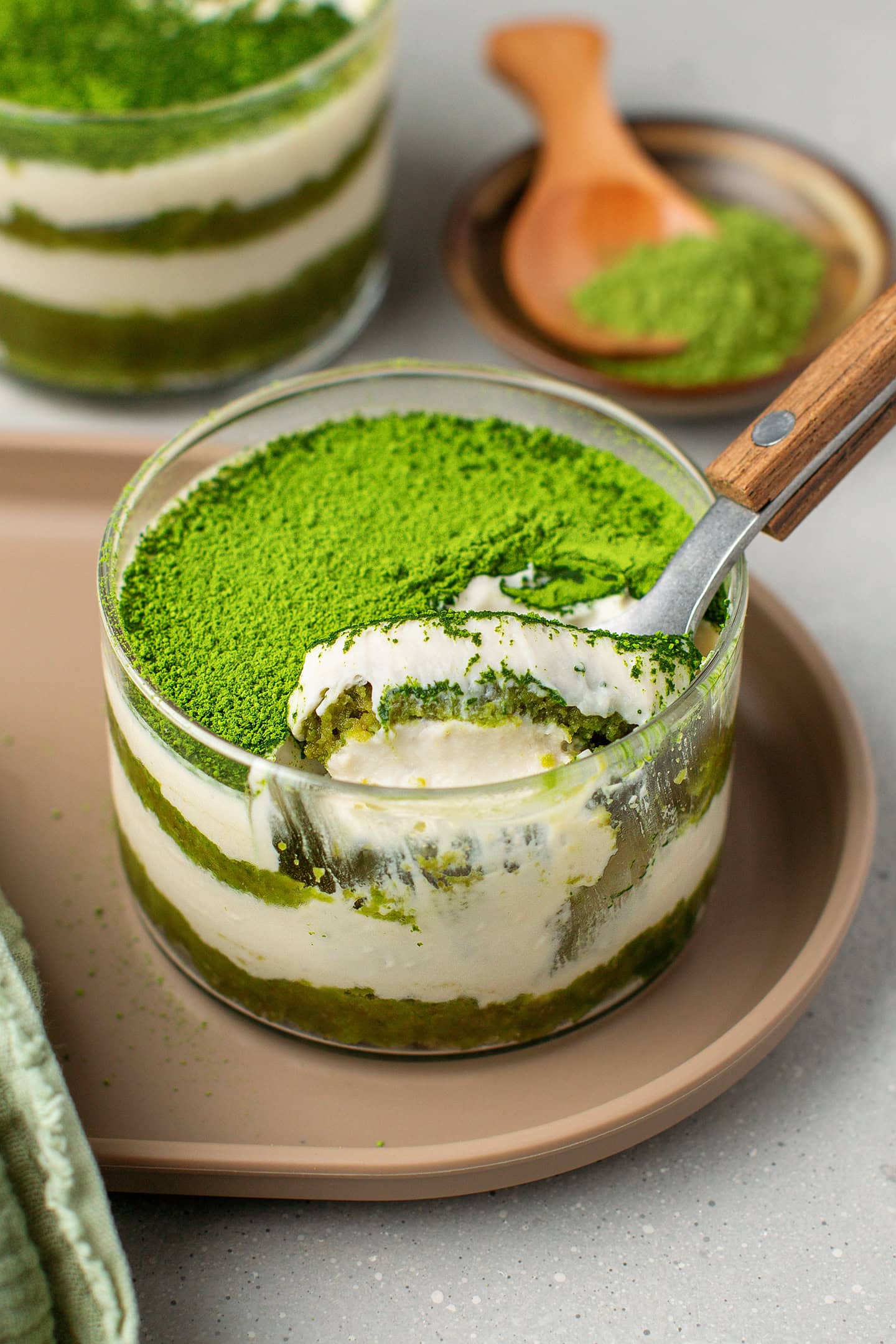 Ramekin filled with layers of vanilla cream and matcha sponge cake.