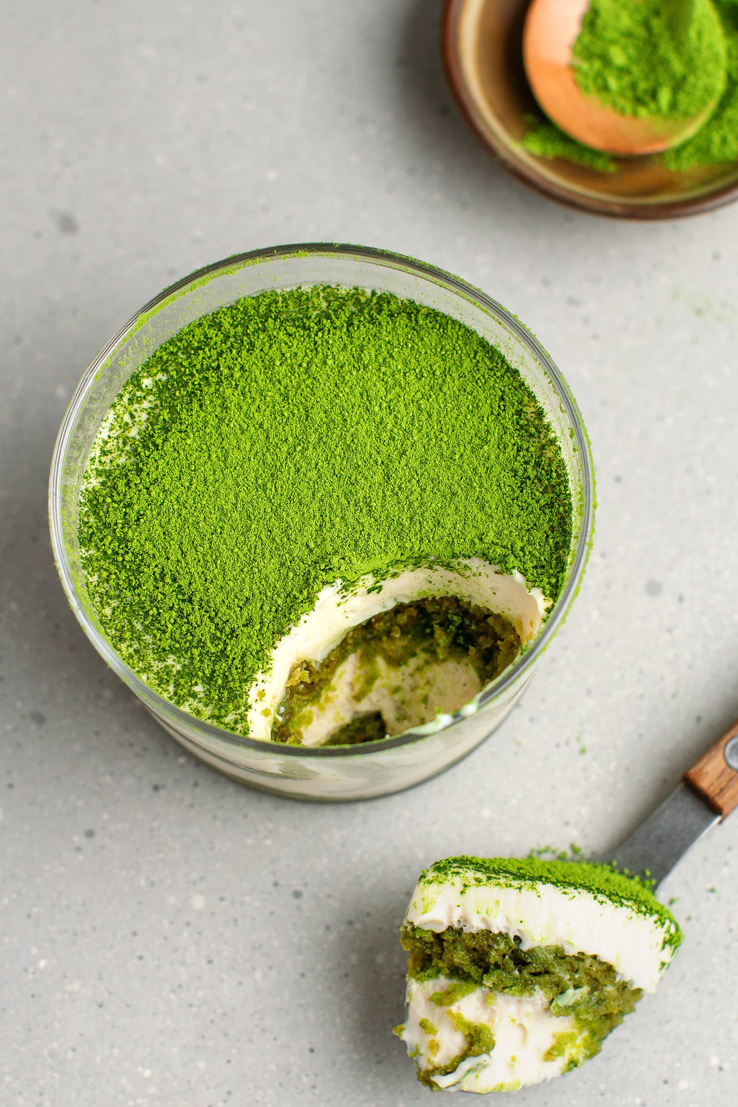 Matcha tiramisu dusted with matcha powder in a small ramekin.