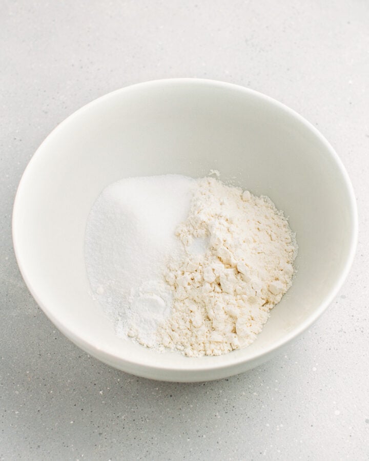 Flour, sugar, baking powder, and baking soda in a mixing bowl.
