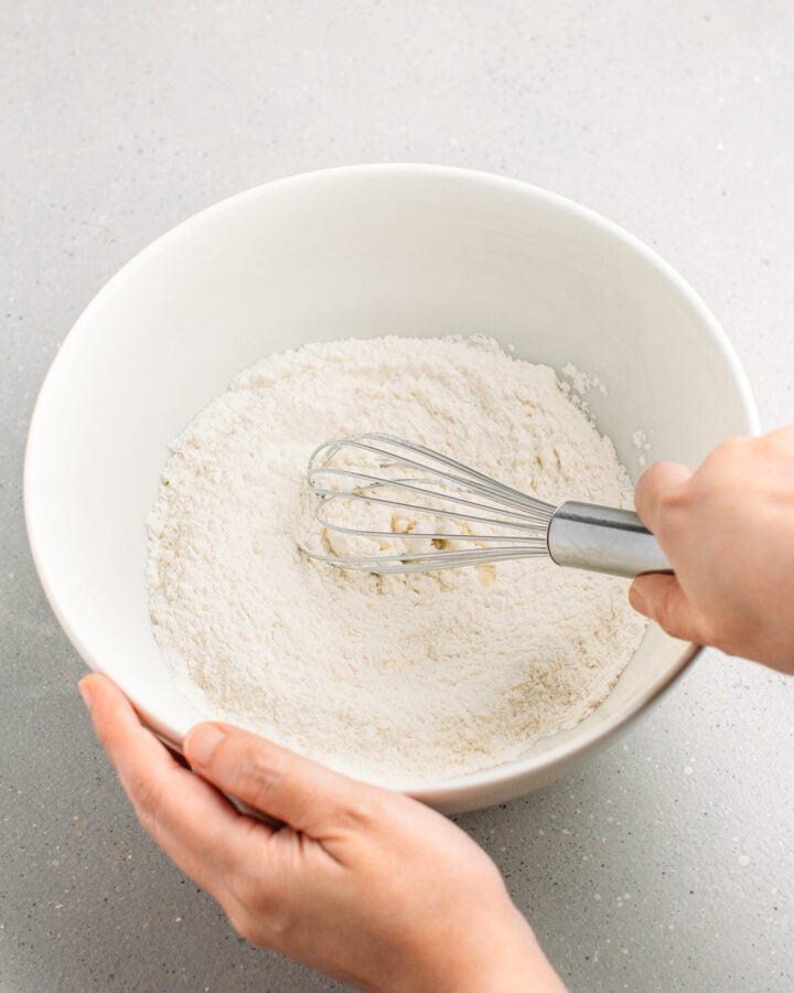 Whisking flour and sugar in a mixing bowl.